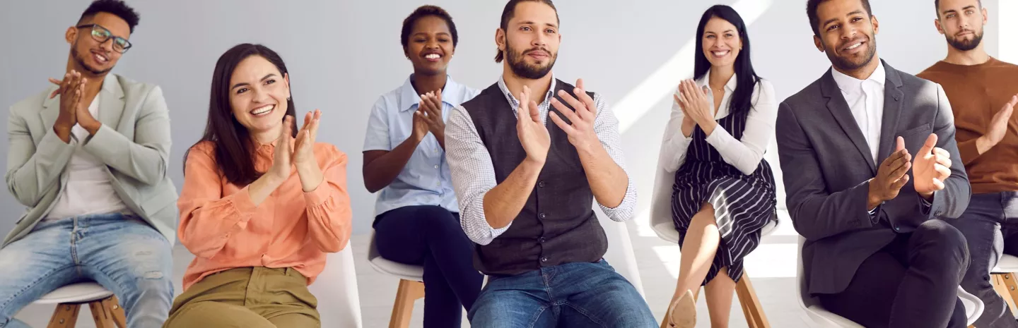 Adult male and female students applauding speaker 