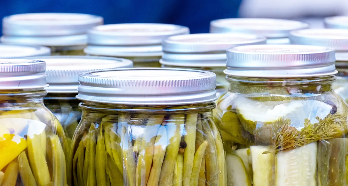 Glass jars containing a variety of canned vegetables