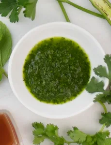 bowl of chimichurri surrounded by whole ingredients