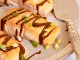 salmon drizzled with black garlic sauce and scallions