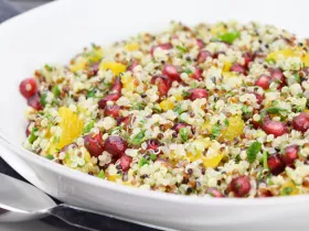 bowl of quinoa, with other chopped vegetables and herbs and pomegranate seeds