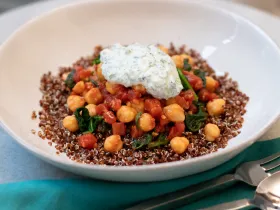 white bowl with chickpea sew topped with yourt