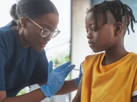 doctor giving child a vaccine in arm