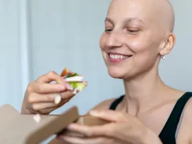 bald woman eating a salad with tofu in it