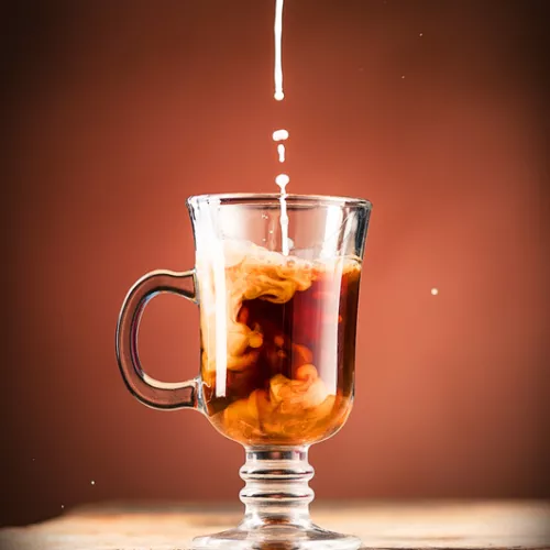 mug of coffee with creamer being poured in