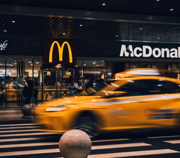 A New York City cab passing a McDonald's at night