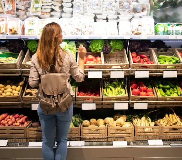 woman in produce section of grocery store