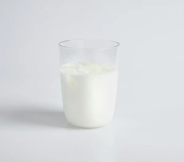 A cup of milk on a white table.