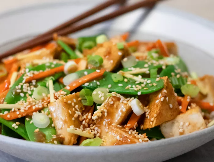 a bowl of ginger sesame tofu with snow peas