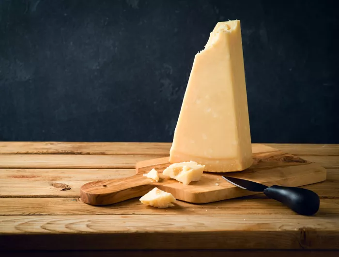 block of cheese on cutting board with knife