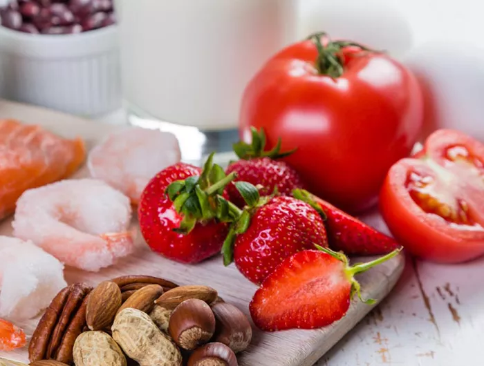 array of foods including tomato, berries, nuts, and shrimp