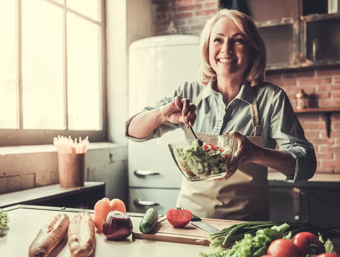 a middle aged woman making a salad