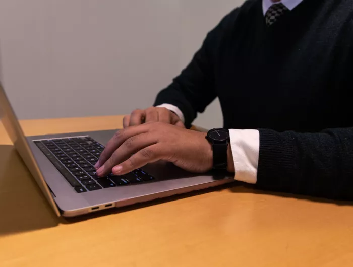 A pair of hands using a laptop