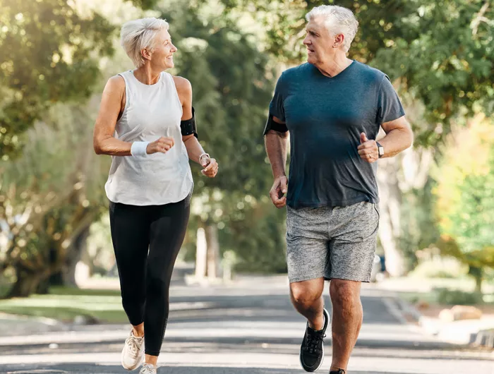 older man and woman jogging outside