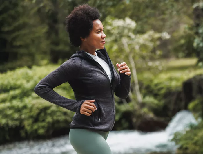 woman running along a creek