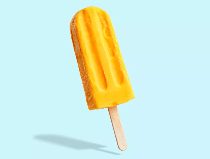 yellow popsicle on light blue background 