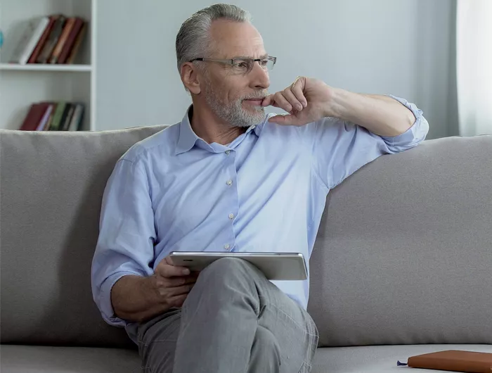Man sitting on a couch looking out of a window