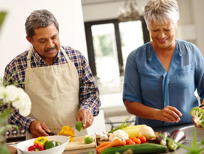 a man and a woman chopping vegetables