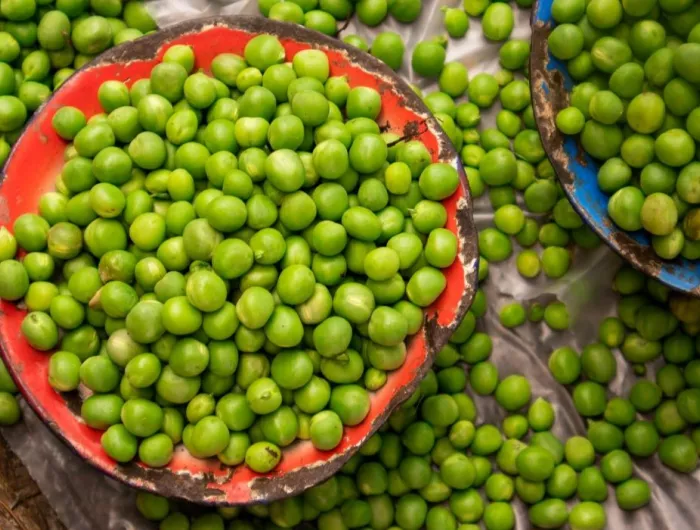 A flat lay of fresh peas in bowls