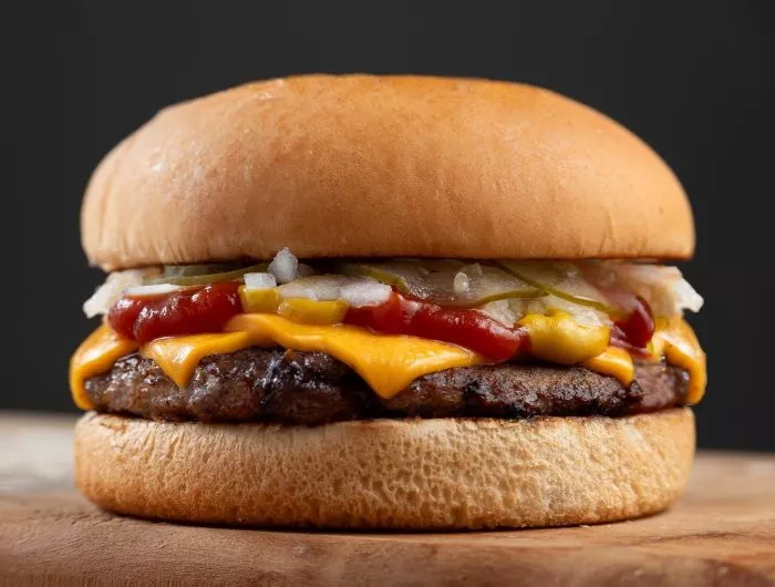 Classic burger with cheese, onions, pickle, mustard, and ketchup