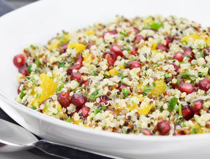 bowl of quinoa, with other chopped vegetables and herbs and pomegranate seeds