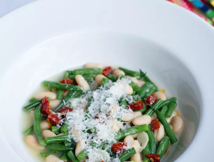 white bowl filled with beans and greens