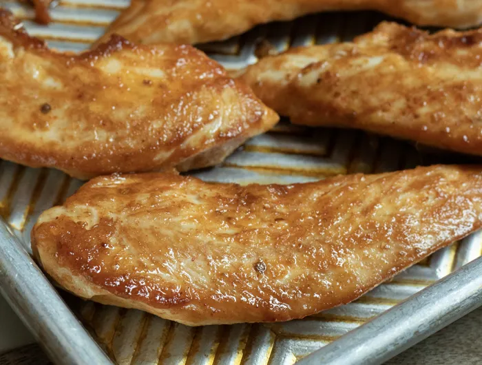 metal sheet pan with breaded chicken on it