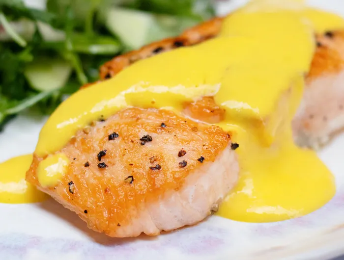 salmon filet with a yellow mango sauce on top