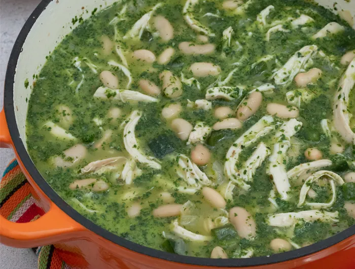 large orange ceramic pot filled with green chicken chili