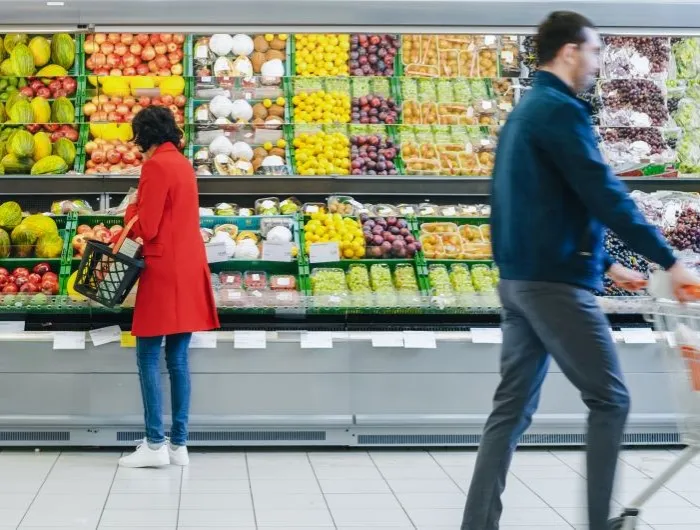 At the Supermarket: Woman Chooses Organic Fruits in the Fresh Produce Section of the Store