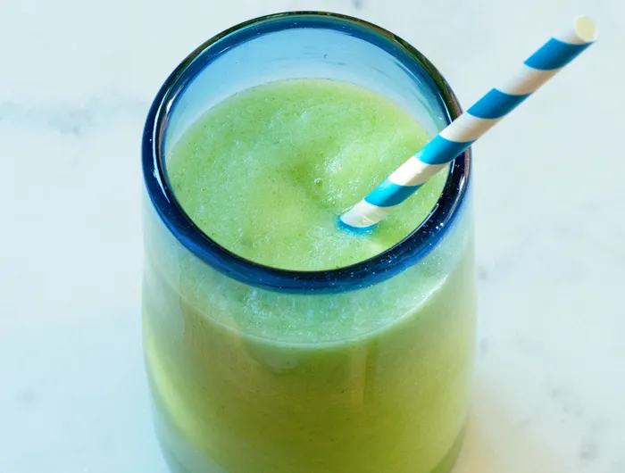 clear glass with blue rim filled with a light green drink