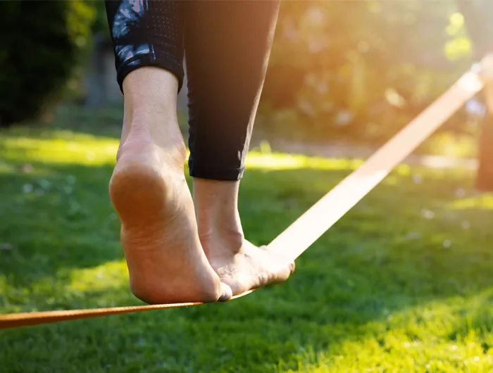 woman's feet walking on a tightrope low to the ground in a park
