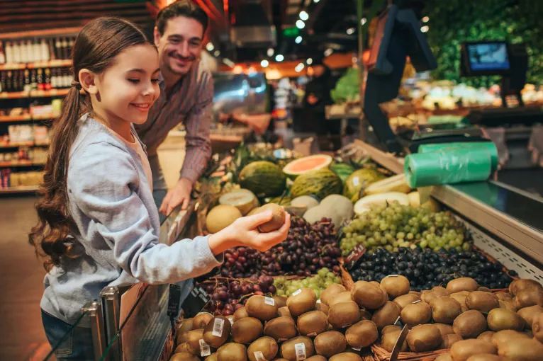 A father and daughter shop for produce