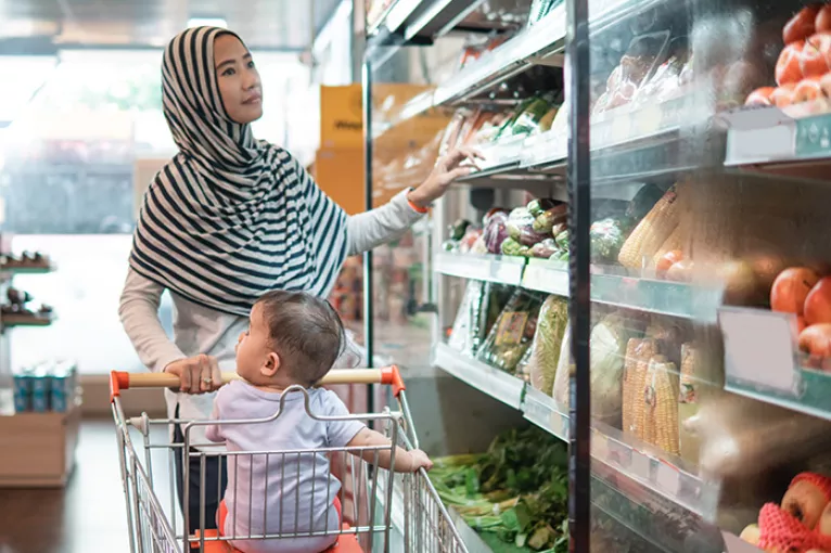 Woman and child grocery store shopping with cart