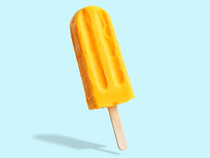 yellow popsicle on light blue background 