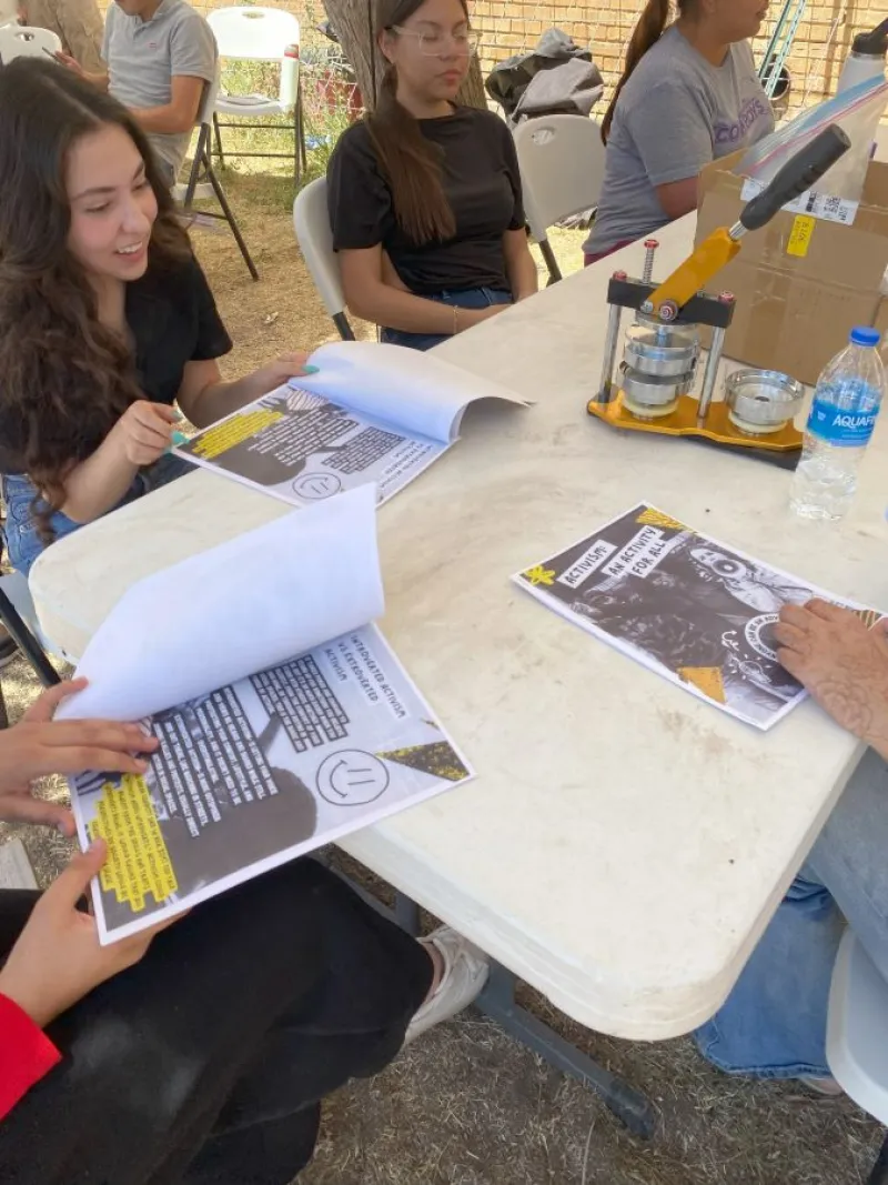 Students reviewing a zine titled “Activism for all.” 