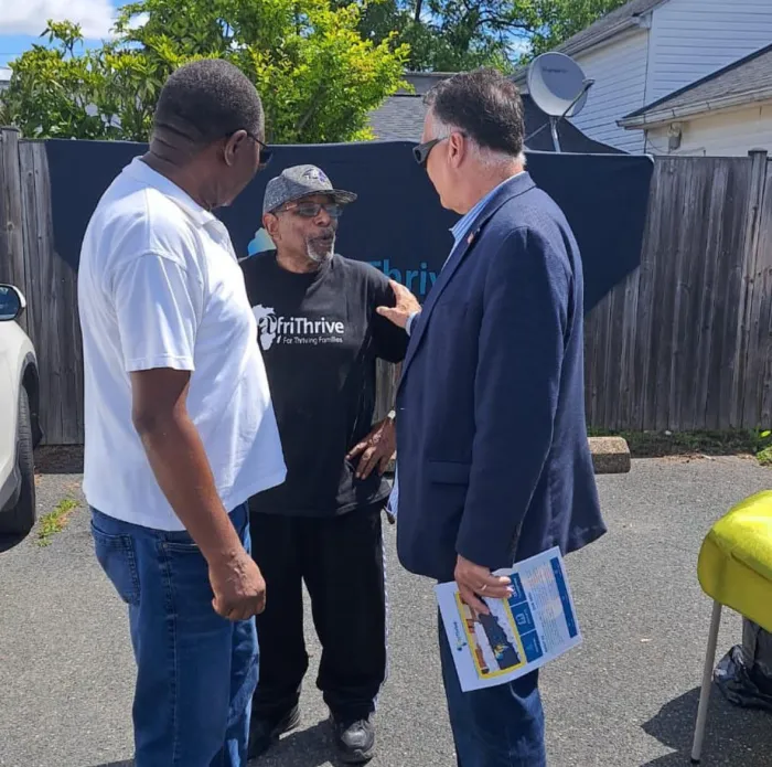 A community member from AfriThrive speaking with Maryland State Senator Johnny Ray Salling