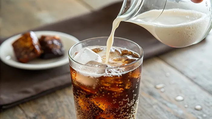 cream being poured into glass of soda