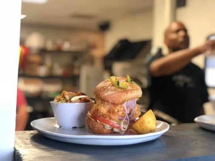 A meal is ready for a customer on the pass-through of a kitchen window at an OKC Black Eats event