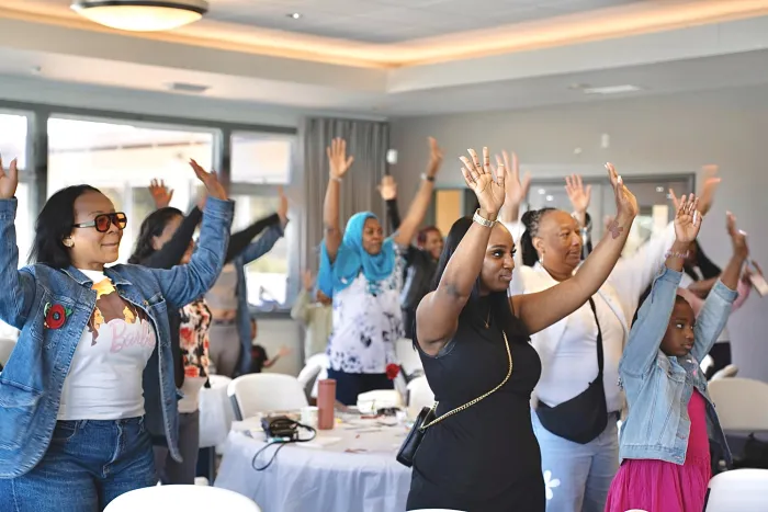 Attendees at a BCDI event do a movement exercise together