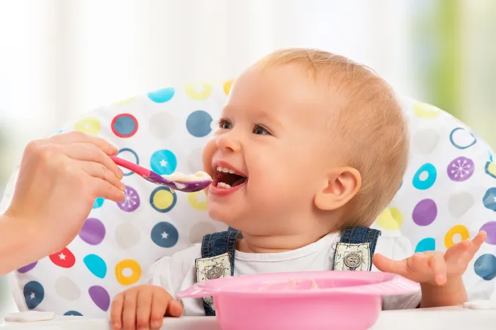 Baby eating food in a highchair