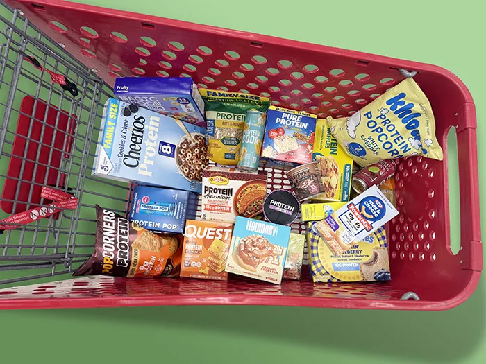 red grocery cart filled with protein junkfoods