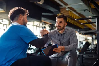 2 men high-fiving at the gym