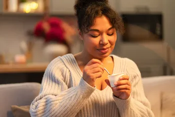 woman eating a cup of yogurt