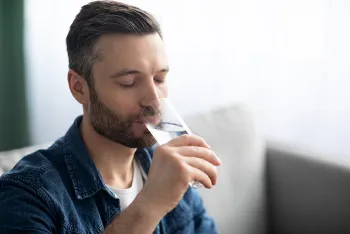 man drinking class of water