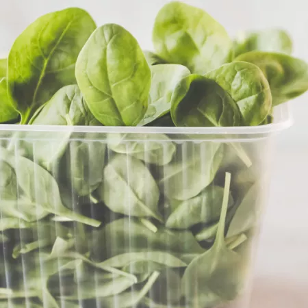 spinach leaves in clear plastic carton