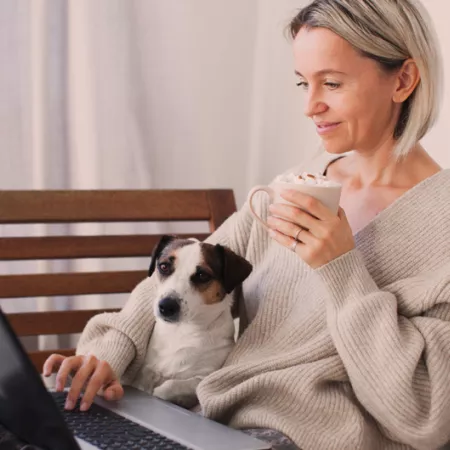woman sitting with dog, sipping coffee