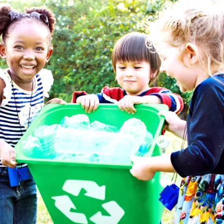 3 children carrying green recycle bin