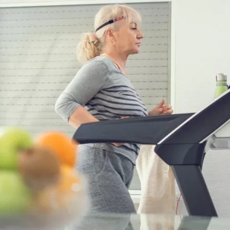older woman walking on treadmill