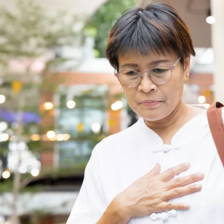 woman standing and holding her chest